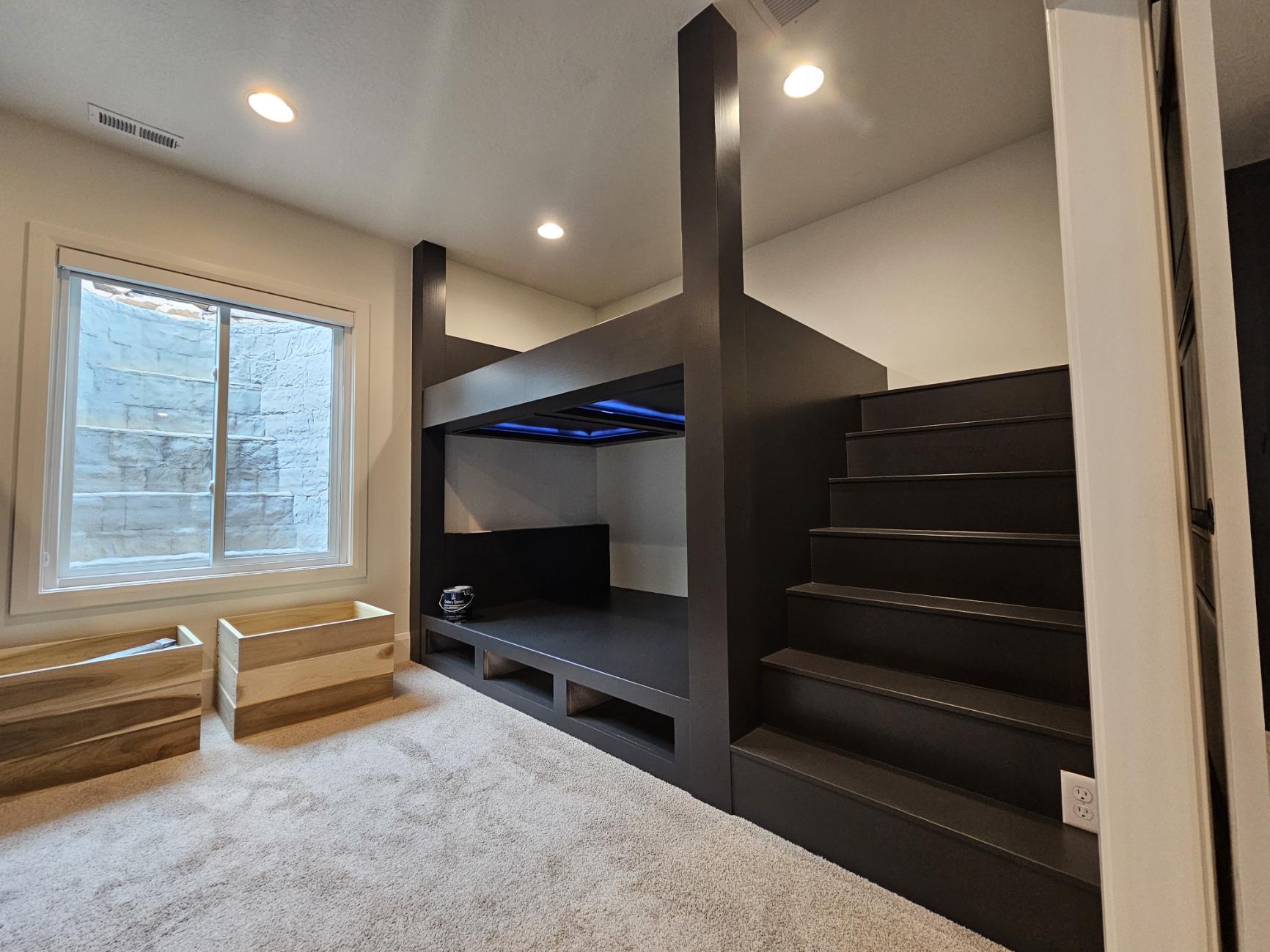 Custom dark-stained bunk beds with stairs and LED lighting